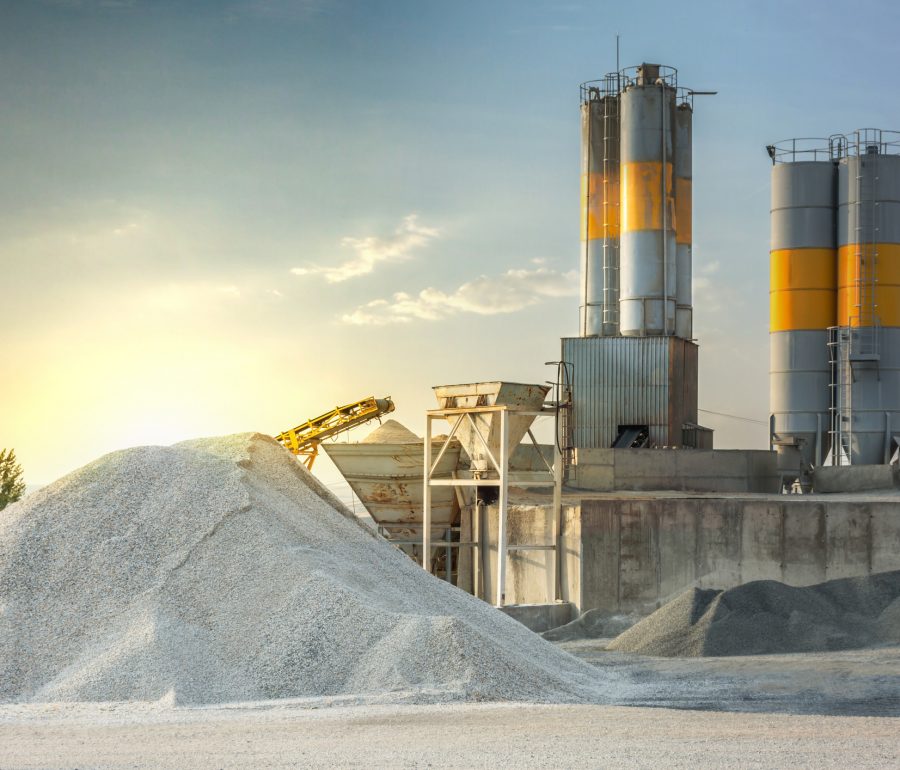 Cement plant with stockpile of cement next to silos