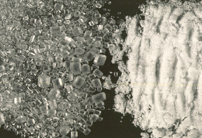 Crystalline bulk material broken (attrited) during pneumatic conveying